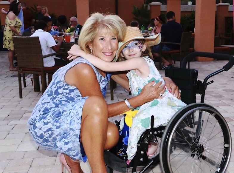 Jennie Bond abraza a una niña en silla de ruedas