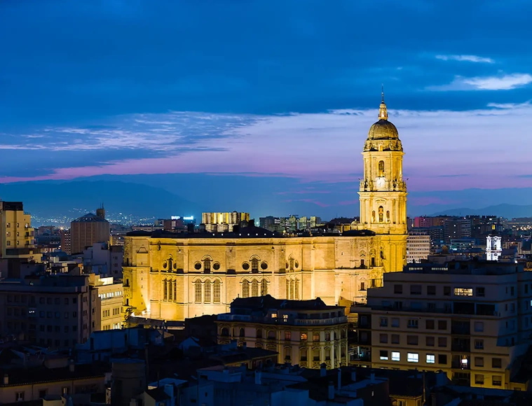 Vista de Málaga con la Catedral iluminada al atardecer