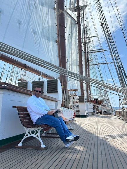 Agustín Almodóbar leyendo en la cubierta de un barco